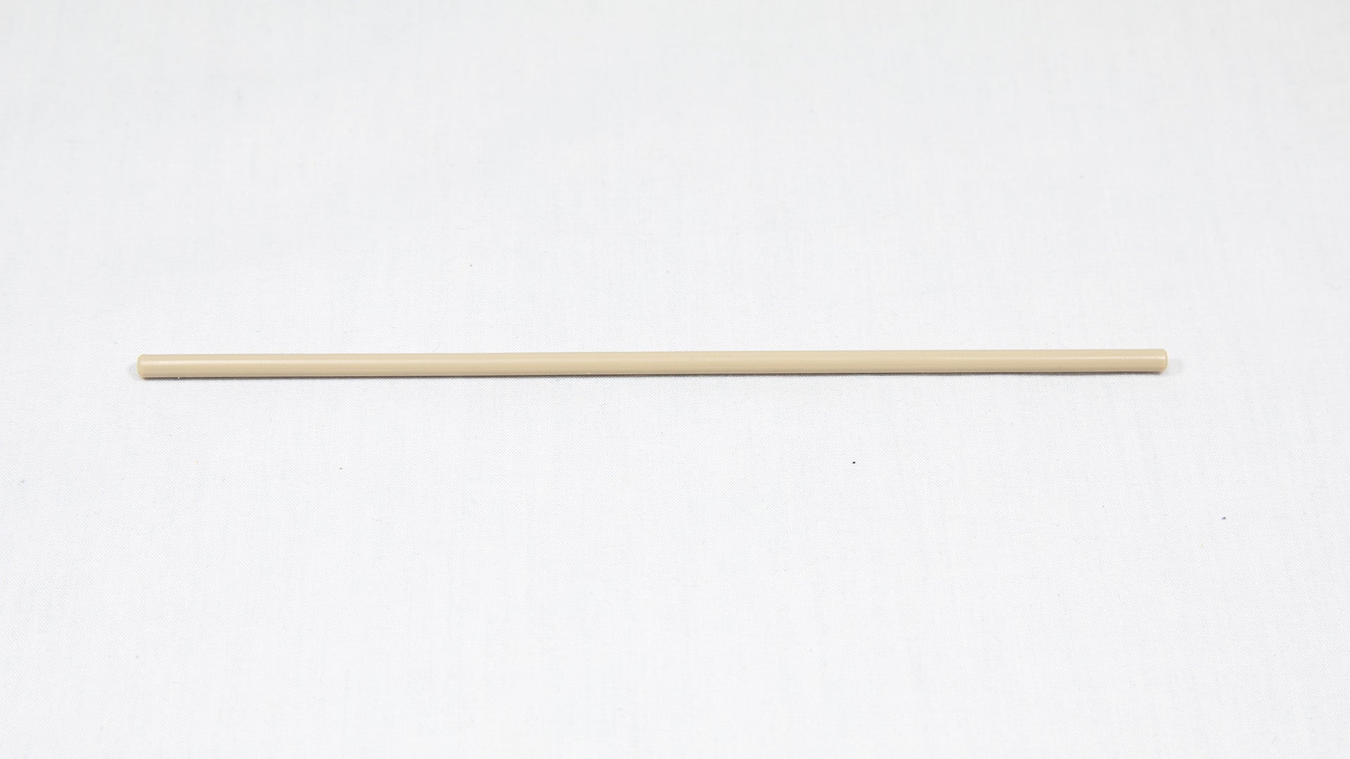 A long cylindrical shaped object pictured on a white background, creating a minimalist composition of everyday items.