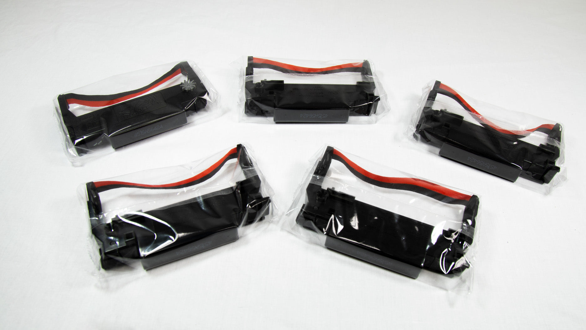 Five black and red plastic cases with matching red and black handles arranged side by side on a white background.

