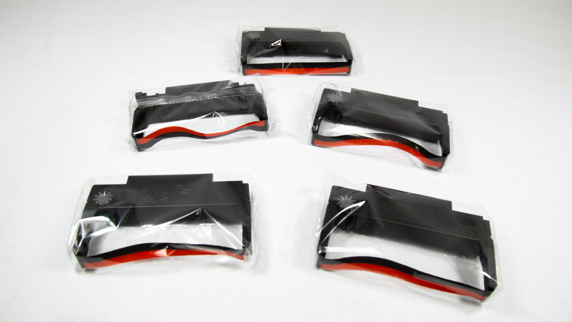 Five black and red plastic cases with matching red and black handles arranged side by side on a white background.
