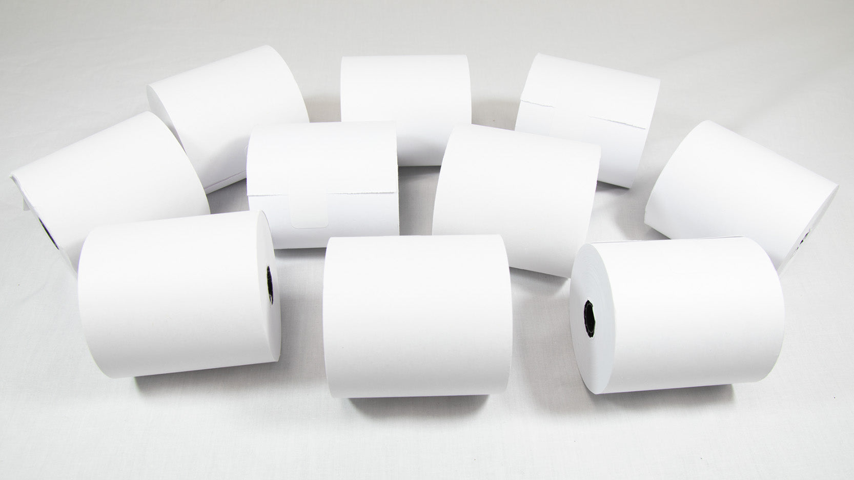 A cluster of white rolls arranged neatly on a white surface, creating a subtle and monochromatic visual effect.
