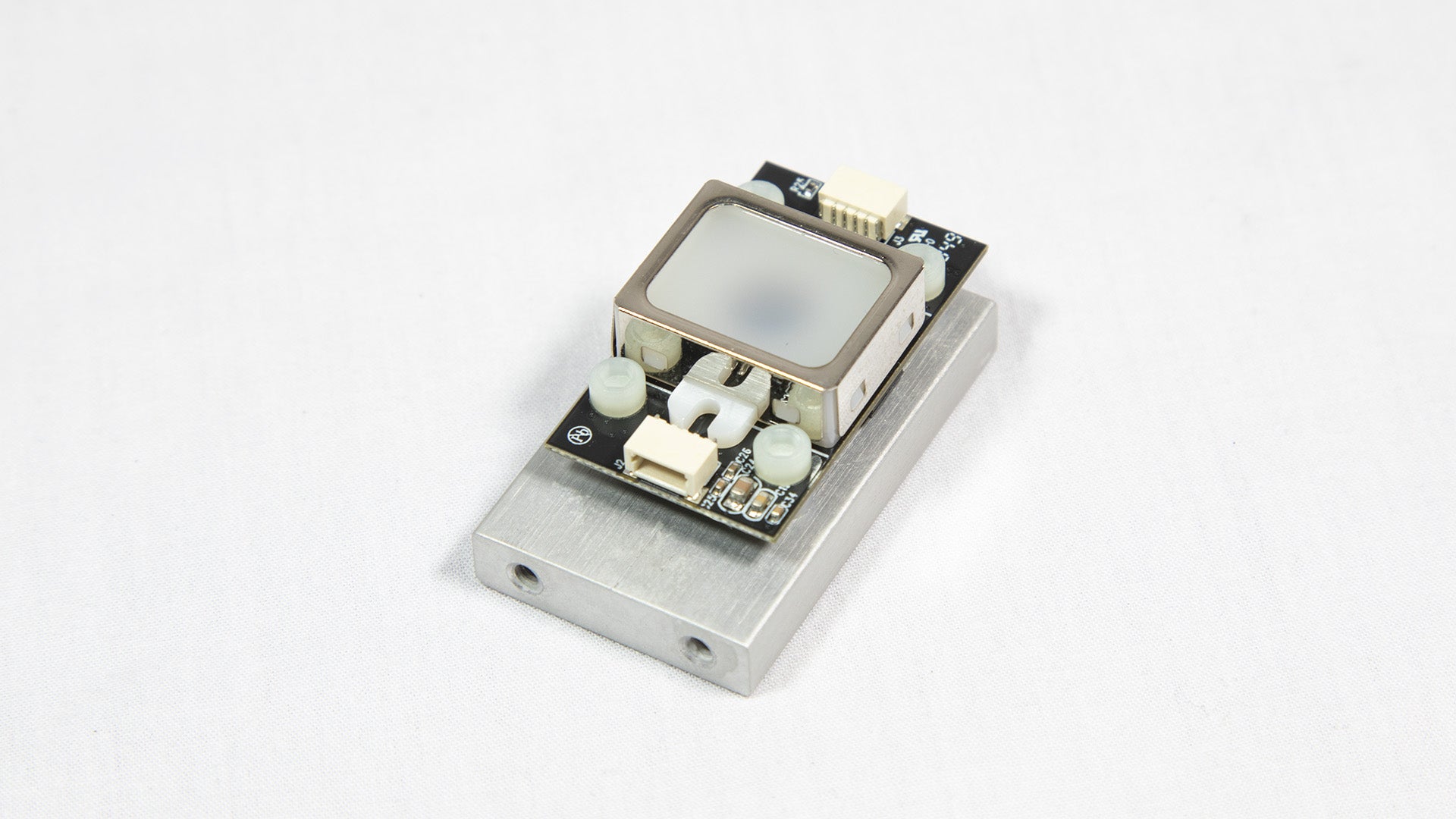 A small electronic device resting on a white surface, showcasing its compact design and modern features.