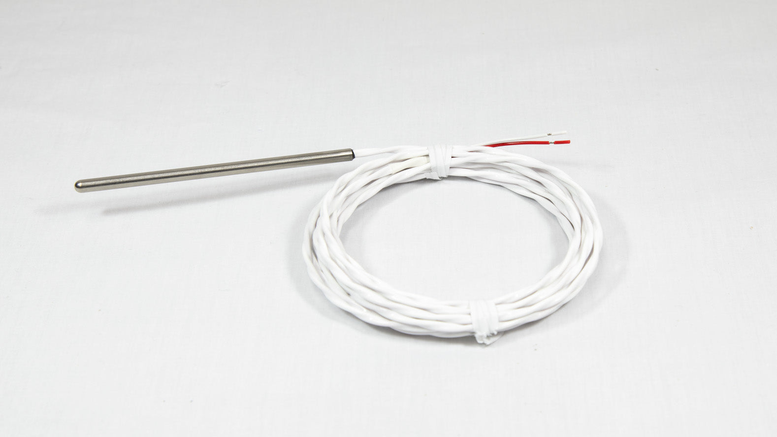 A close-up of a white cable with a stainless steel probe attached.