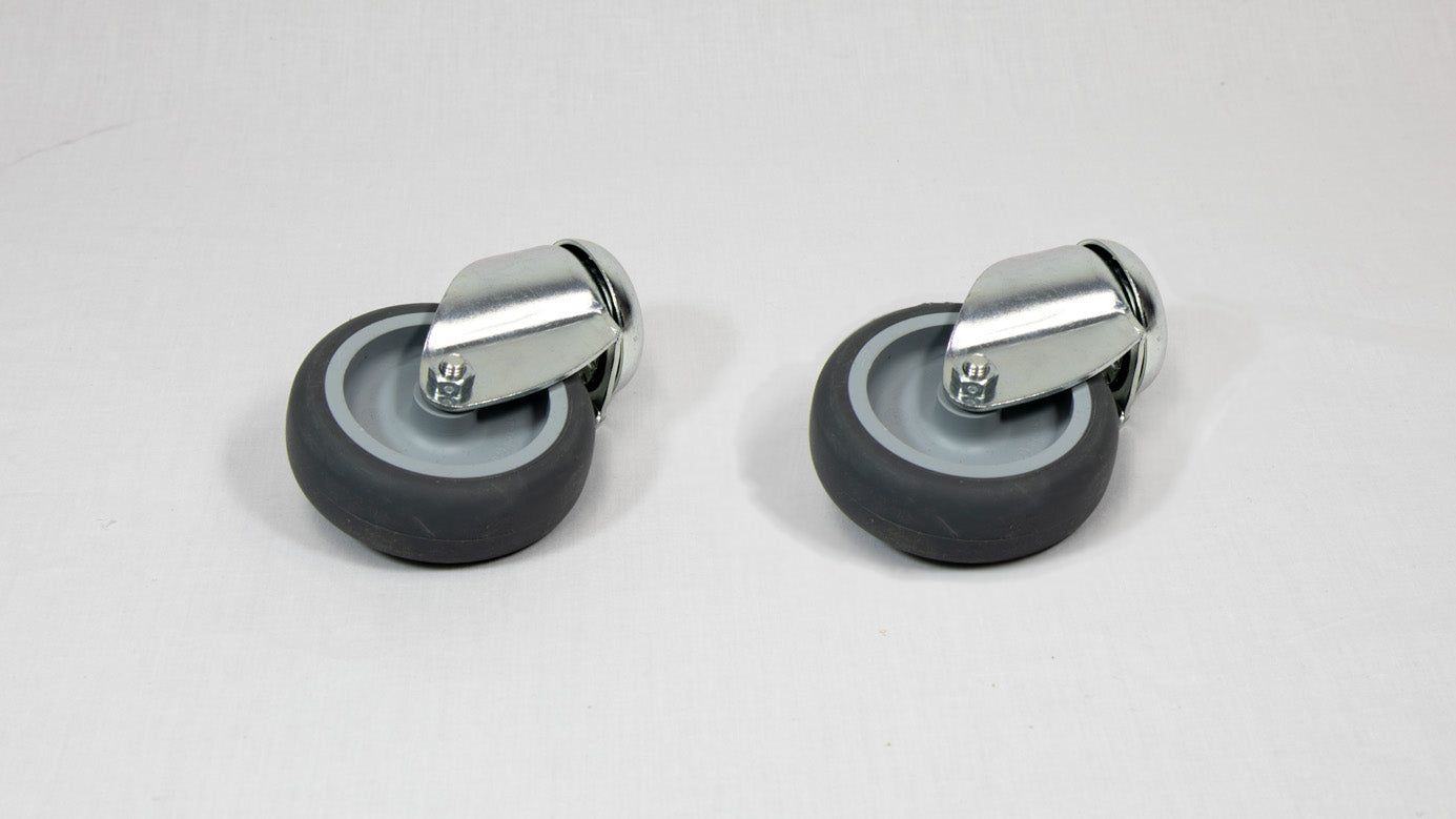 Two black wheels with silver mounts positioned on a white surface, showcasing a simple and functional design.